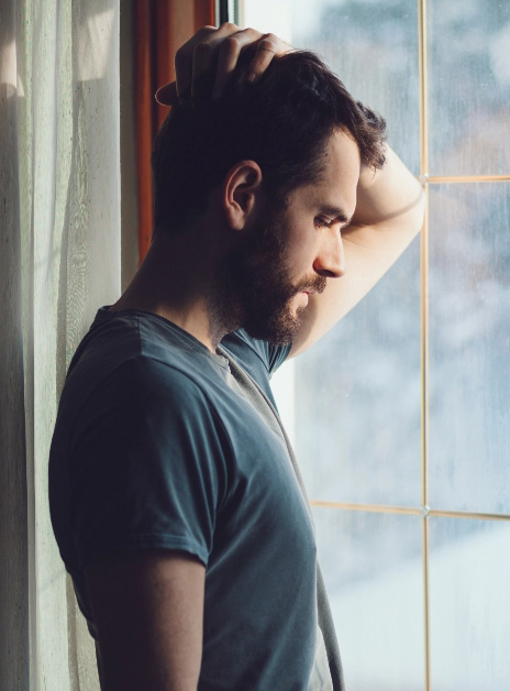 Sad man looking out window